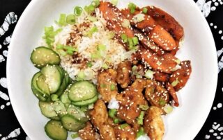 bowl with rice, pickled cucumbers, chicken, scallions and carrots